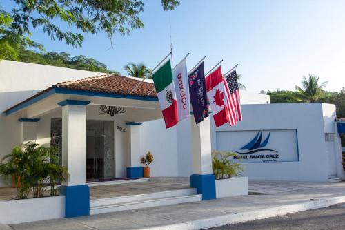 a building with several flags in front of it at Hotel Santa Cruz Huatulco in Santa Cruz Huatulco