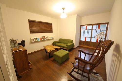 a living room with a green chair and a couch at sumica apartments in Nikko