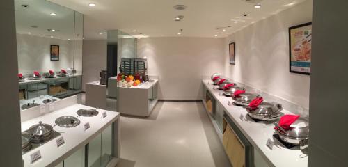 a large kitchen with sinks and counters with red napkins at JinJiang Inn Pingyang Taiyuan Road Hotel in Taiyuan