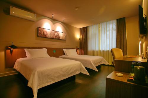 A bed or beds in a room at JinJiang Inn Pingyang Taiyuan Road Hotel
