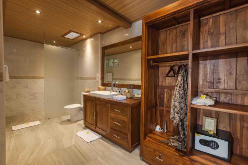 a bathroom with a sink and a toilet and a mirror at Sweet Ginger Villa by Prasi in Ubud