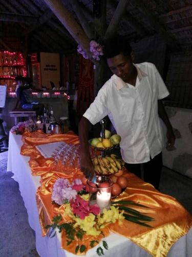a man standing in front of a table with food at Eden Villa in Belle Mare