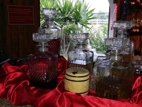 a group of glass bottles sitting on a red cloth at Eden Villa in Belle Mare