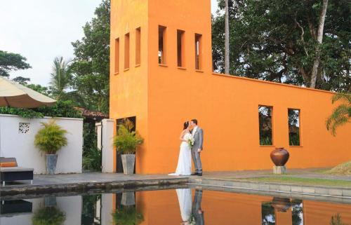 a bride and groom standing in front of a building at Kahanda Kanda in Koggala