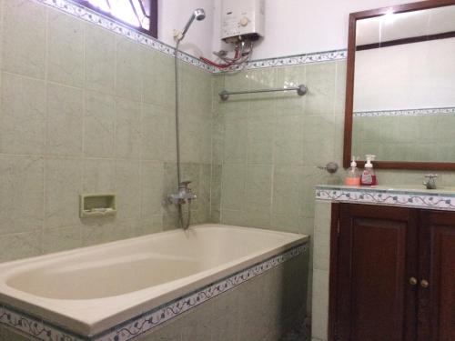 a bathroom with a tub and a mirror at de'Rumah Rindu Alam in Batu