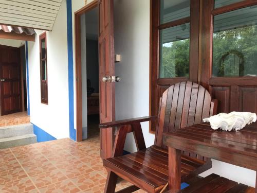 a wooden table and a chair in front of a door at No Name Bungalow Haad Yao in Haad Yao