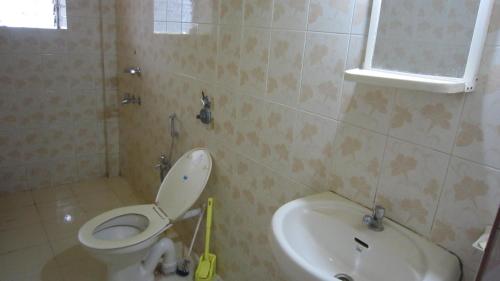 ein Bad mit einem WC und einem Waschbecken in der Unterkunft Mariano Gracinda resort in Calangute