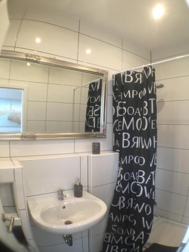 ein Bad mit einem Waschbecken und einem Spiegel in der Unterkunft Apartmenthaus Kühnen in Kevelaer