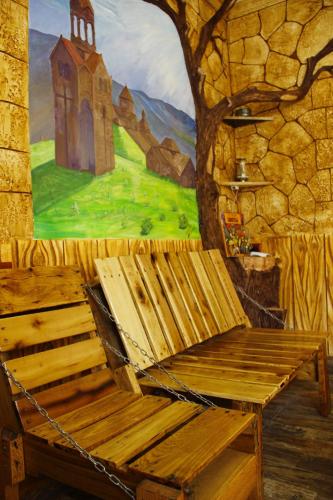 a wooden bench chained to a wall with a painting at Mini House in Alaverdi