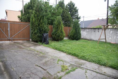 a backyard with a fence and a grass yard at Ubytování Sýkora Apartments in Veľký Meder
