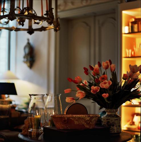 a table with a vase of flowers on a table at B&B The Verhaegen in Ghent