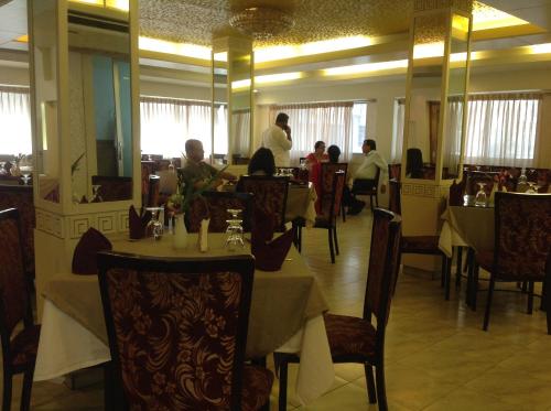 a restaurant with people sitting at tables in a restaurant at Hotel Ornate in Dhaka