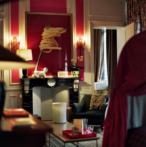 a living room with a fireplace and a red wall at B&B The Verhaegen in Ghent