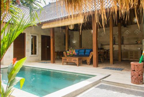 a villa with a swimming pool and a patio at Lily Lane Villas in Ubud