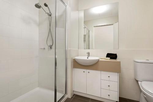 a white bathroom with a sink and a shower at Quest Ballarat in Ballarat