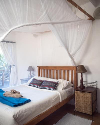 a bedroom with a bed with a canopy at Vila la Mar Vilanculo in Vilanculos