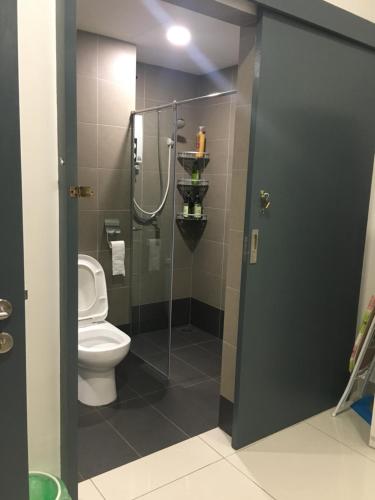 a bathroom with a toilet and a glass shower stall at Petaling Jaya Atria Sofo Suite in Petaling Jaya