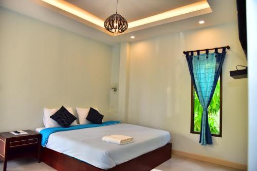 1 dormitorio con cama y ventana en The House at Pranburi, en Pran Buri