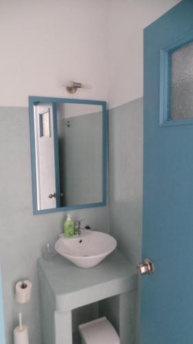 a bathroom with a white sink and a mirror at Delfini Hotel in Skala