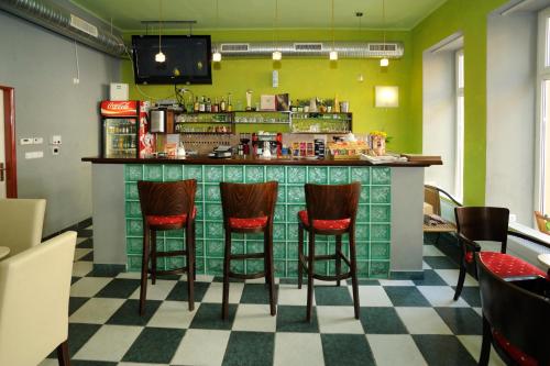 a bar in a restaurant with four stools at Hotel City in Pardubice