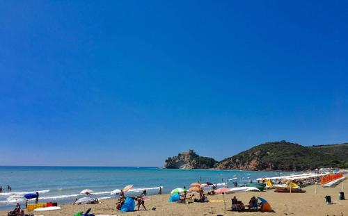 a group of people on a beach with umbrellas at Camping Village Rocchette in Castiglione della Pescaia