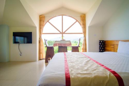 a bedroom with a bed and a large window at XinFu Traveler Inn in Taiping