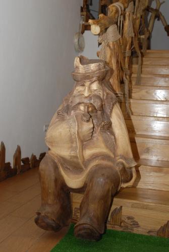 a wooden statue of a person sitting on the floor at Туристично розважальний комплекс "Стіжок" in Berehomet
