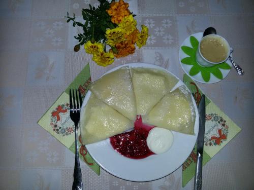 einen Teller mit einem Stück Essen auf dem Tisch in der Unterkunft Kolo Druziv in Slawske