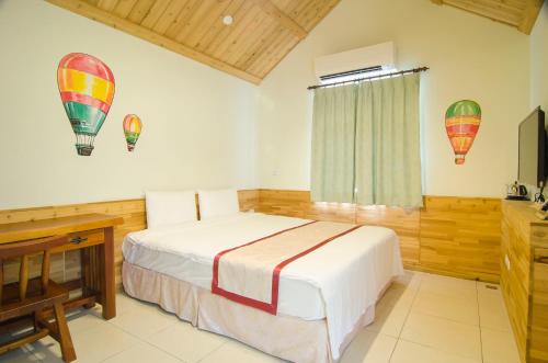 a bedroom with a bed and hot air balloons on the wall at XinFu Traveler Inn in Taiping