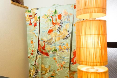 a room with two lamps and a curtain with birds on it at Kyoto Matsuya in Kyoto