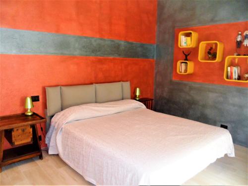 a bedroom with a white bed and an orange wall at 4effe Home in Sestri Levante