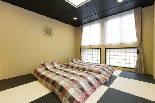two beds in a room with two windows at Kyoto Matsuya in Kyoto
