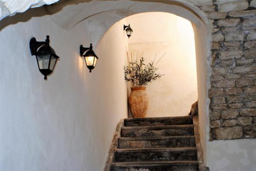 a hallway with a stairway with a vase and lights at Modica Castle in Modica
