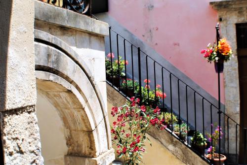 a balcony with flowers on the side of a building at Modica Castle in Modica