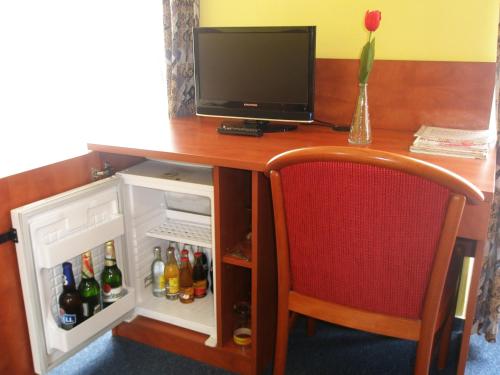 a desk with a television and a small refrigerator at Hotel Morava in Znojmo