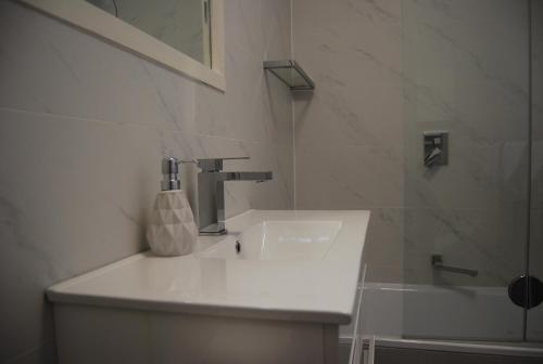bagno bianco con lavandino e doccia di Balcony Retreat Apartment by Ready Set Host a Melbourne