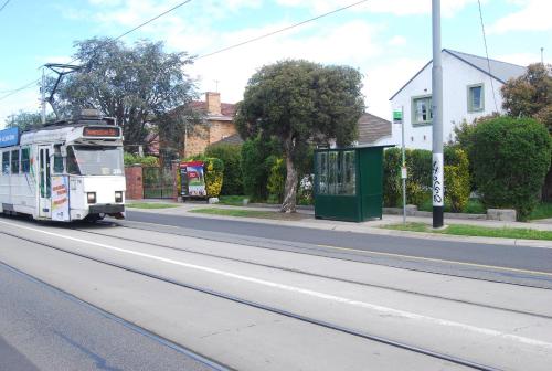 Un autobus urbano che guida lungo una strada di Balcony Retreat Apartment by Ready Set Host a Melbourne