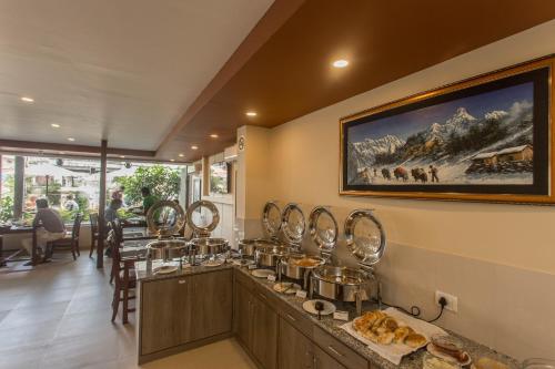 a restaurant with a counter with many pots of food at Oasis Kathmandu Hotel in Kathmandu