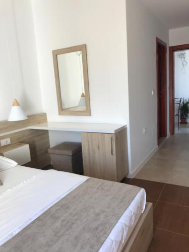 a white room with a bed and a mirror at Apartments Stanaj in Ulcinj