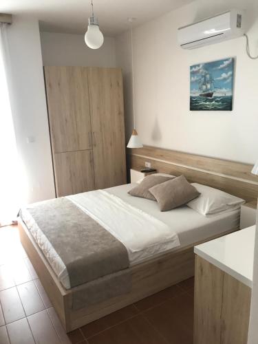 a bedroom with a large bed and a cabinet at Apartments Stanaj in Ulcinj