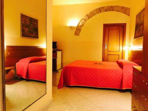 ein Hotelzimmer mit 2 Betten und einem Spiegel in der Unterkunft Corato room economy in Corato
