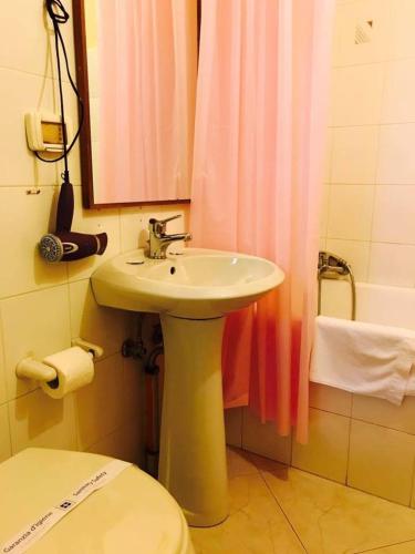 a bathroom with a sink and a pink shower curtain at Corato room economy in Corato
