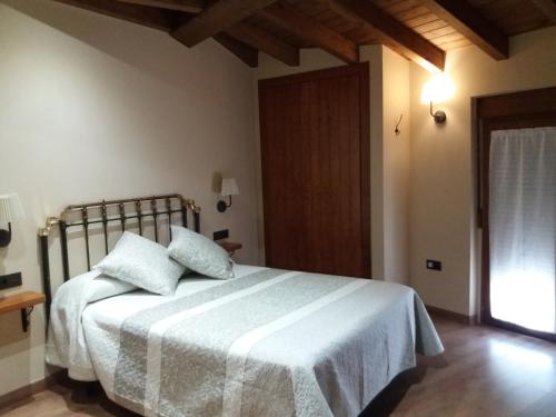 a bedroom with a bed with white sheets and a window at El Cobijo de los Arribes in Fermoselle