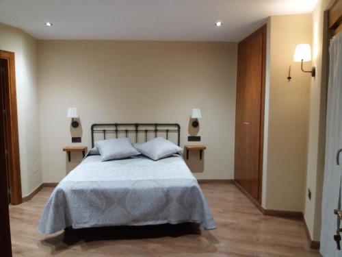 a bedroom with a bed and two night stands at El Cobijo de los Arribes in Fermoselle