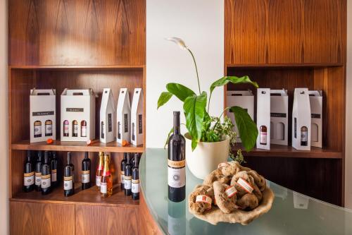 a shelf with bottles of wine and a plant at Hotel Borovnik in Tisno