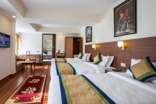 una habitación de hotel con 4 camas en una habitación en Oasis Kathmandu Hotel en Katmandú