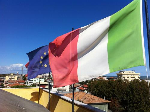 a flag and a european flag on top of a building at Hotel Viking in Rimini