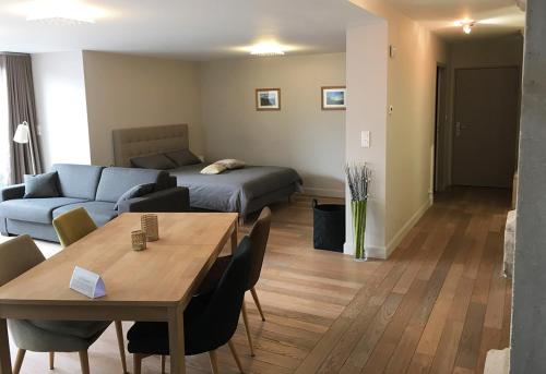 a living room with a couch and a table and a bed at L'Aparté in Nancy