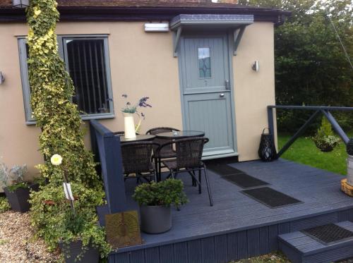 a patio with a table and chairs on a deck at The Stables - Deer Park Farm in Solihull