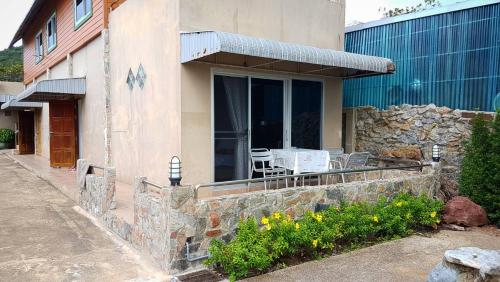a house with a patio with a table and chairs at Charm de Chao Lao in Chao Lao Beach